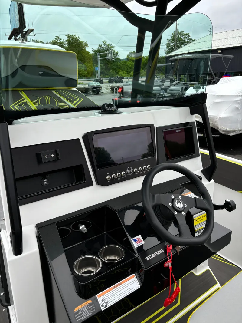 Slide: The Image of 2025 Scarab 255 Open SE boat dashboard with steering wheel and digital displays. - 12