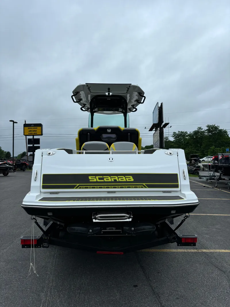 Slide: The Image of 2025 Scarab 255 Open SE boat interior with warning labels, speaker, and cup holder. - 5