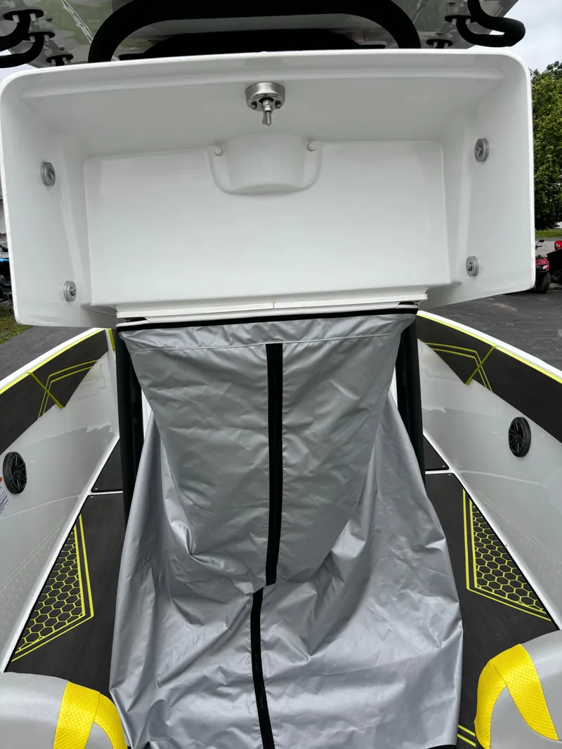 Slide: The Image of 2025 Scarab 255 Open SE boat interior with storage compartment and gray cover. - 7