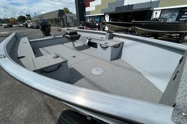 Slide: The Image of 2025 Lund 1675 Alaskan Tiller boat, spacious interior, parked outdoors. - 11