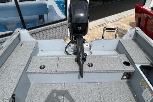 Slide: The Image of 2025 Lund 1675 Alaskan Tiller boat interior with motor, gray seating, and storage compartments. - 14