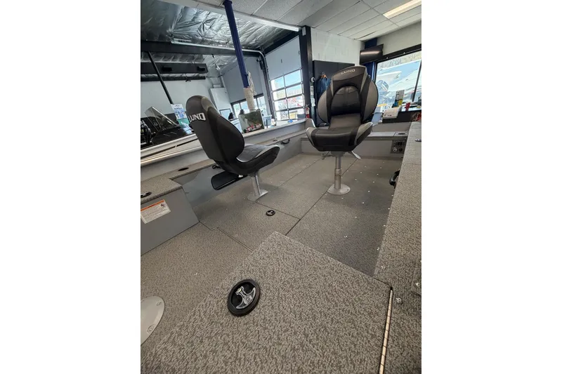 Slide: The Image of 2025 Lund 1675 Alaskan Tiller boat interior with two swivel seats in a showroom. - 22