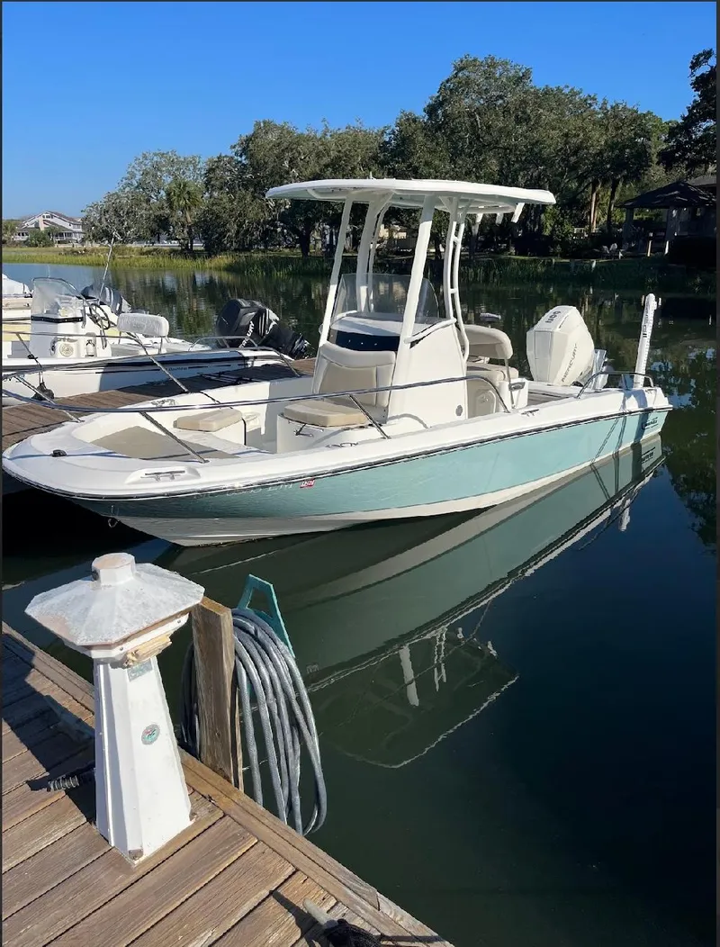 Slide: The Image of 2019 Boston Whaler 210 Dauntless boat docked on calm water. - 1