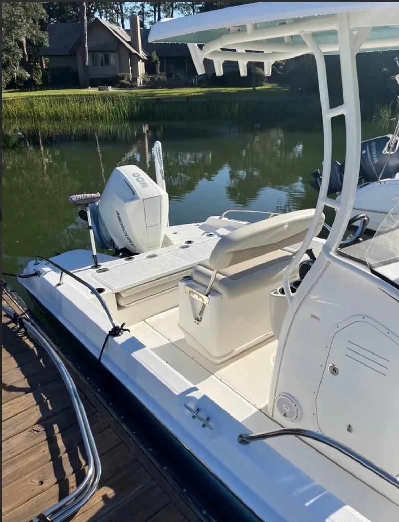 Slide: The Image of 2019 Boston Whaler 210 Dauntless boat docked by a serene lake. - 3
