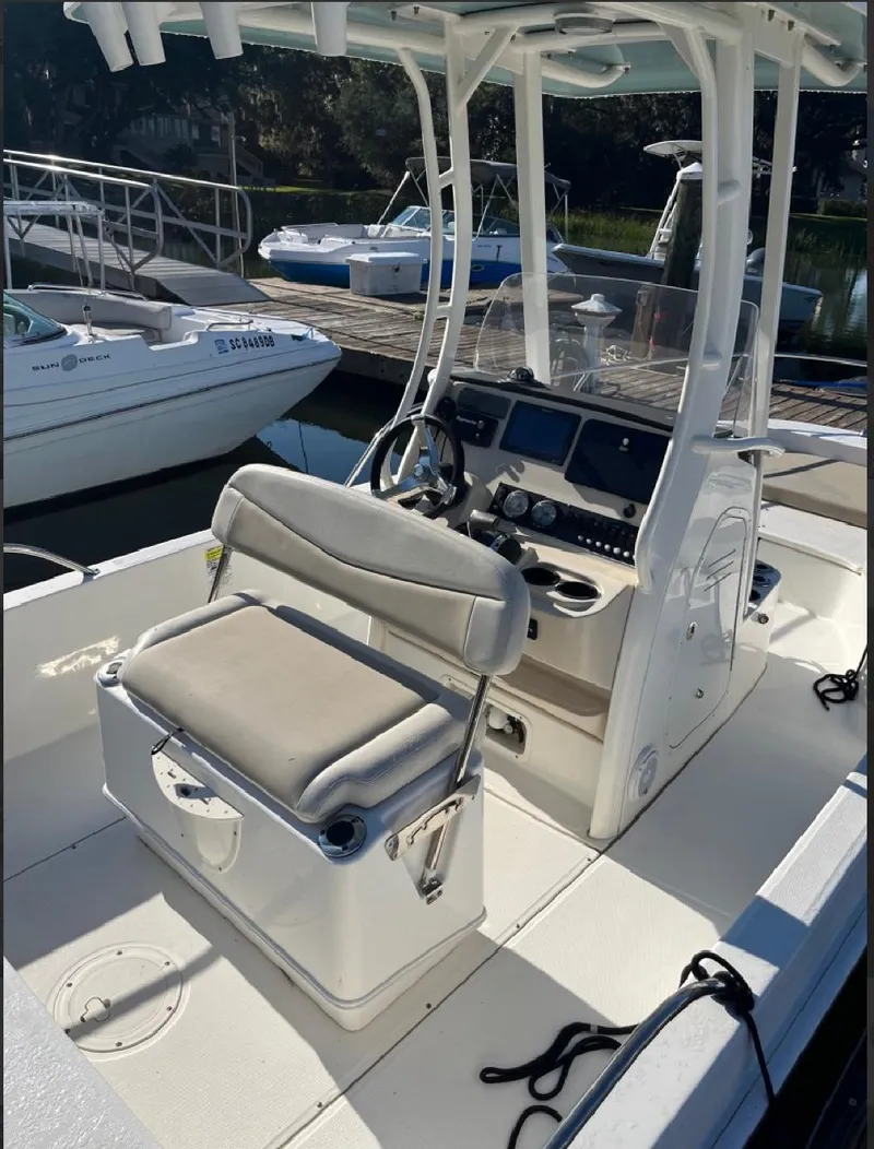 Slide: The Image of 2019 Boston Whaler 210 Dauntless boat interior with helm and seating at dock. - 6