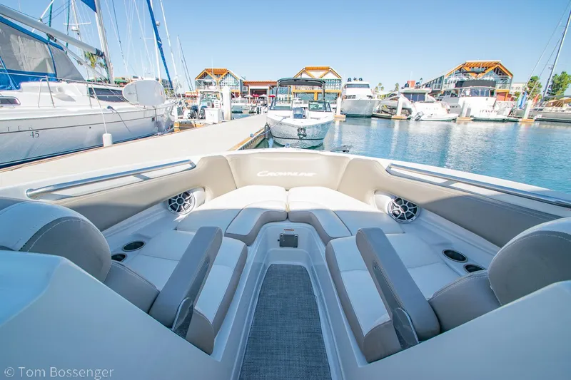 Slide: The Image of 2021 Crownline 255 XSS boat interior at marina, showcasing seating and speakers. - 11