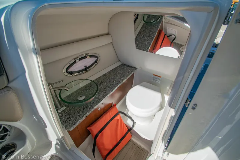 Slide: The Image of 2021 Crownline 255 XSS boat interior with toilet, sink, and storage. - 19