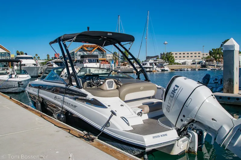 Slide: The Image of 2021 Crownline 255 XSS boat docked at a marina with Suzuki outboard engine. - 3