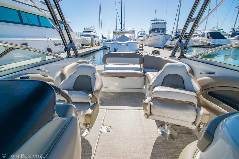 Slide: The Image of 2021 Crownline 255 XSS boat interior with seating, docked at marina. - 6