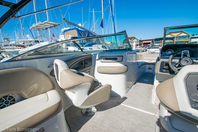 Slide: The Image of 2021 Crownline 255 XSS boat interior with beige seating and modern dashboard. - 9