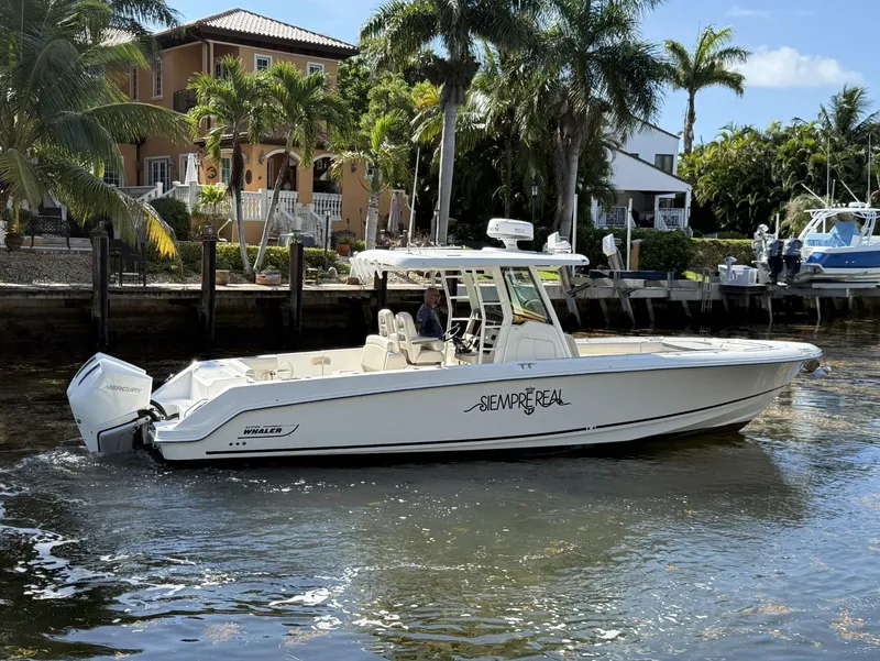 Slide: The Image of 2020 Boston Whaler 330 Outrage boat on water near tropical waterfront homes. - 12