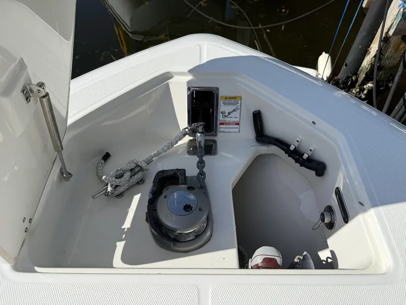 Slide: The Image of 2020 Boston Whaler 330 Outrage anchor compartment with rope and winch. - 13