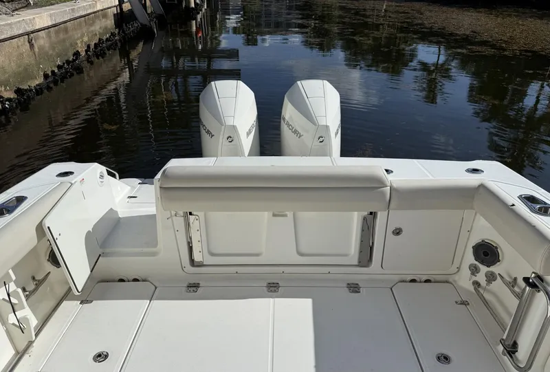 Slide: The Image of 2020 Boston Whaler 330 Outrage boat with twin Mercury engines, docked in calm water. - 25
