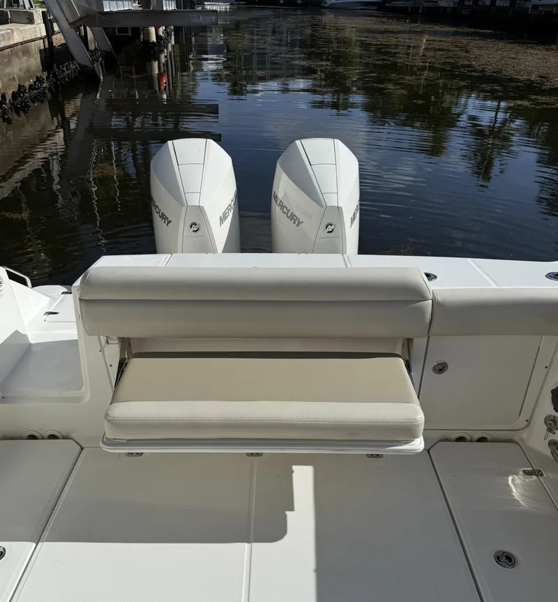Slide: The Image of 2020 Boston Whaler 330 Outrage boat with dual Mercury engines, docked by the water. - 27