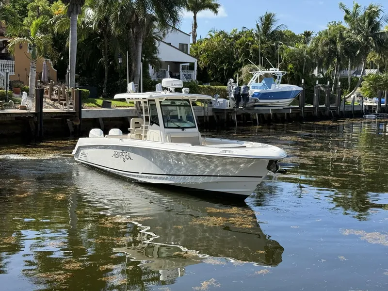 Slide: The Image of 2020 Boston Whaler 330 Outrage boat docked in a scenic waterfront setting. - 3