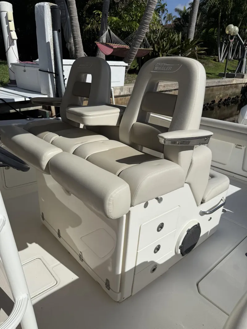 Slide: The Image of 2020 Boston Whaler 330 Outrage boat seating area with beige upholstery. - 30