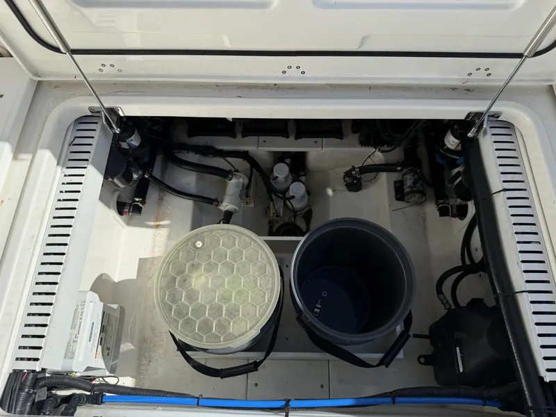 Slide: The Image of 2020 Boston Whaler 330 Outrage engine compartment with equipment and storage buckets. - 33