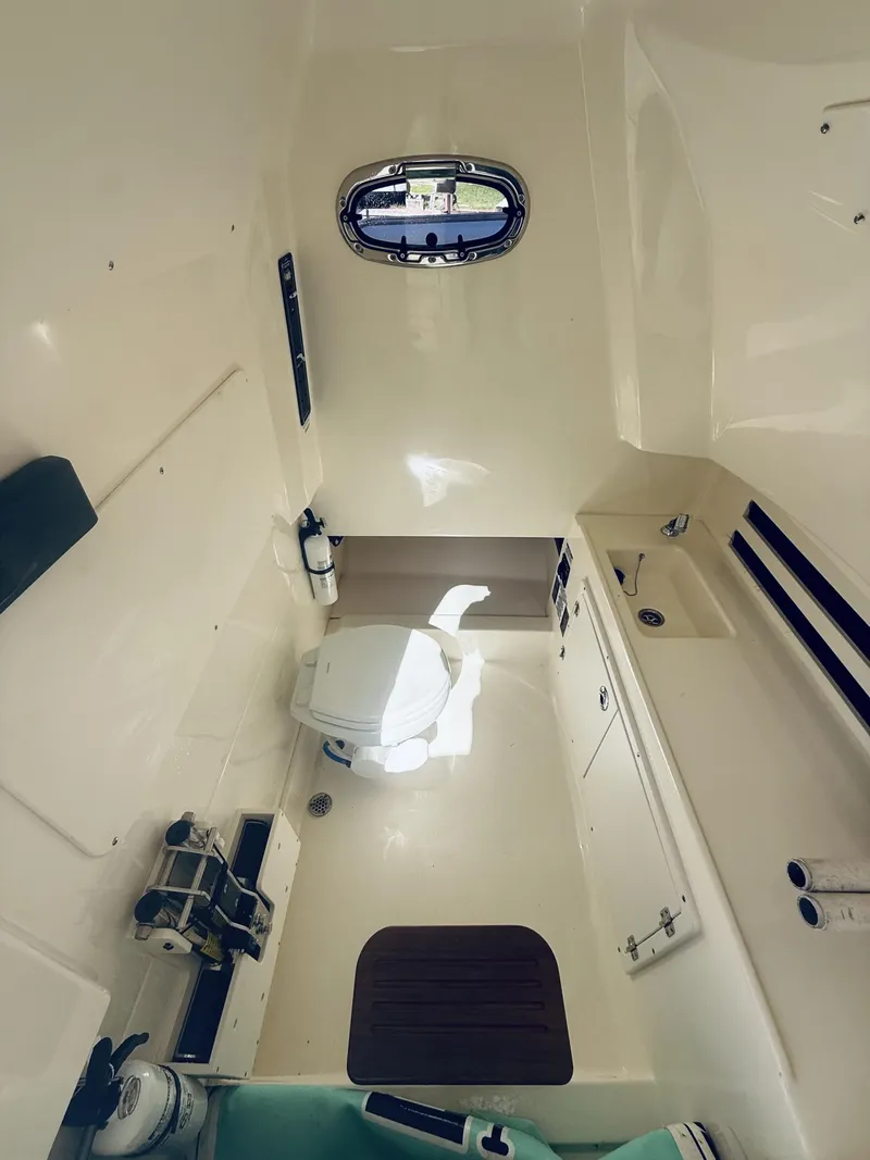 Slide: The Image of 2020 Boston Whaler 330 Outrage cabin interior with toilet and sink. - 34