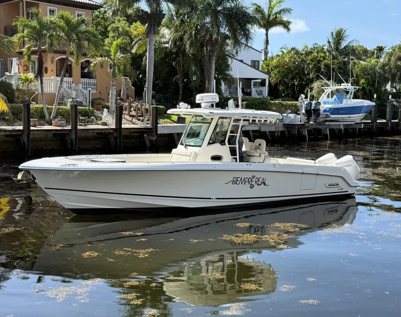 Slide: The Image of 2020 Boston Whaler 330 Outrage boat docked by tropical waterfront homes. - 5