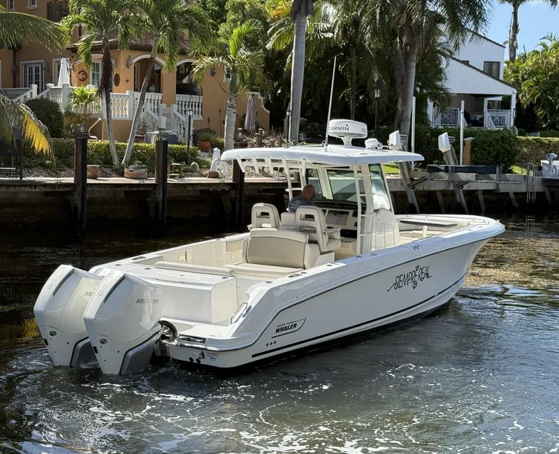 Slide: The Image of 2020 Boston Whaler 330 Outrage boat docked near tropical waterfront homes. - 9