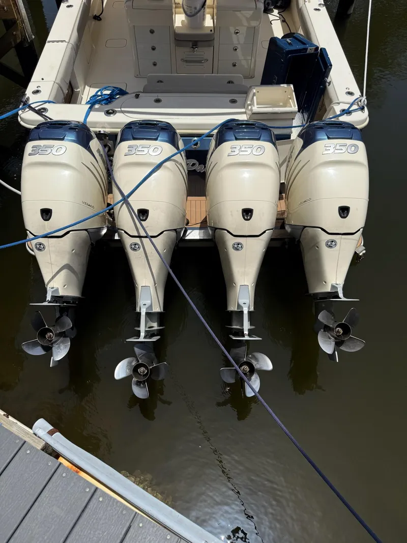 Slide: The Image of 2019 Scout 420 LXF boat docked in a scenic marina with palm trees. - 13