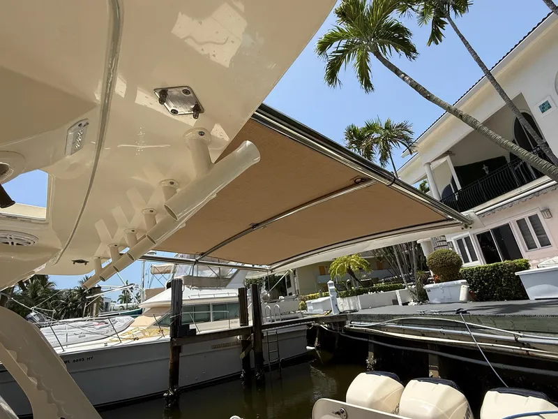 Slide: The Image of 2019 Scout 420 LXF boat with rod holders, docked under clear blue sky. - 16