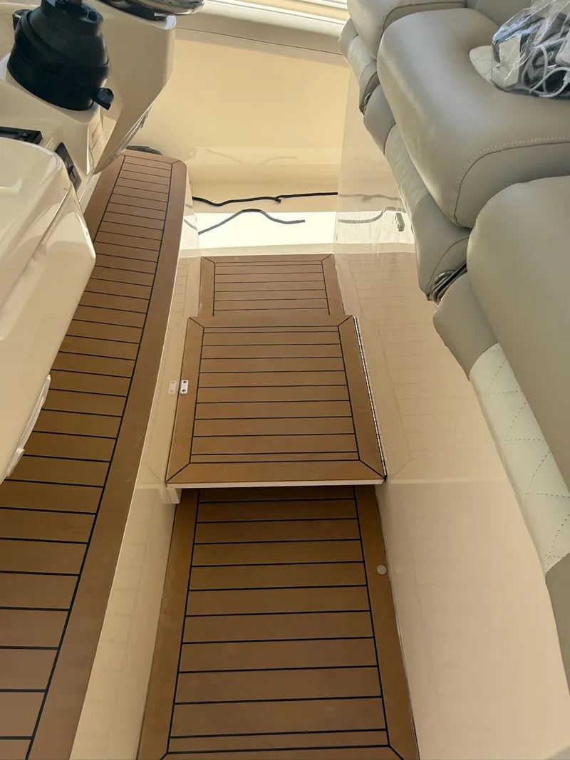 Slide: The Image of 2019 Scout 420 LXF boat interior with teak flooring and cushioned seating. - 23