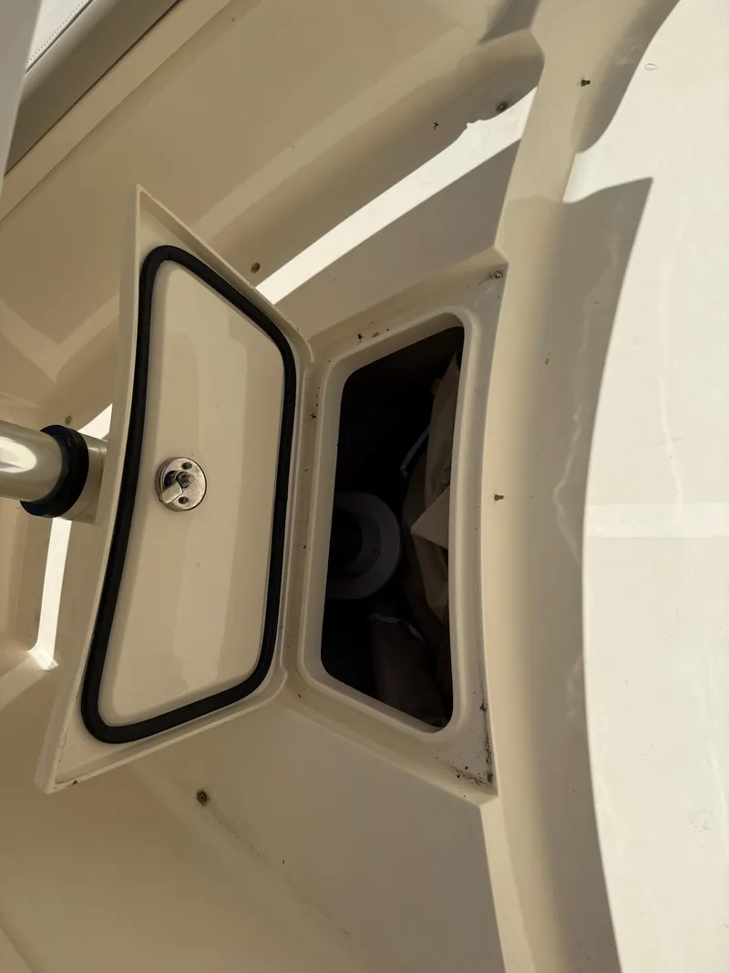 Slide: The Image of 2019 Scout 420 LXF boat storage compartment with cup holders and beige interior. - 41