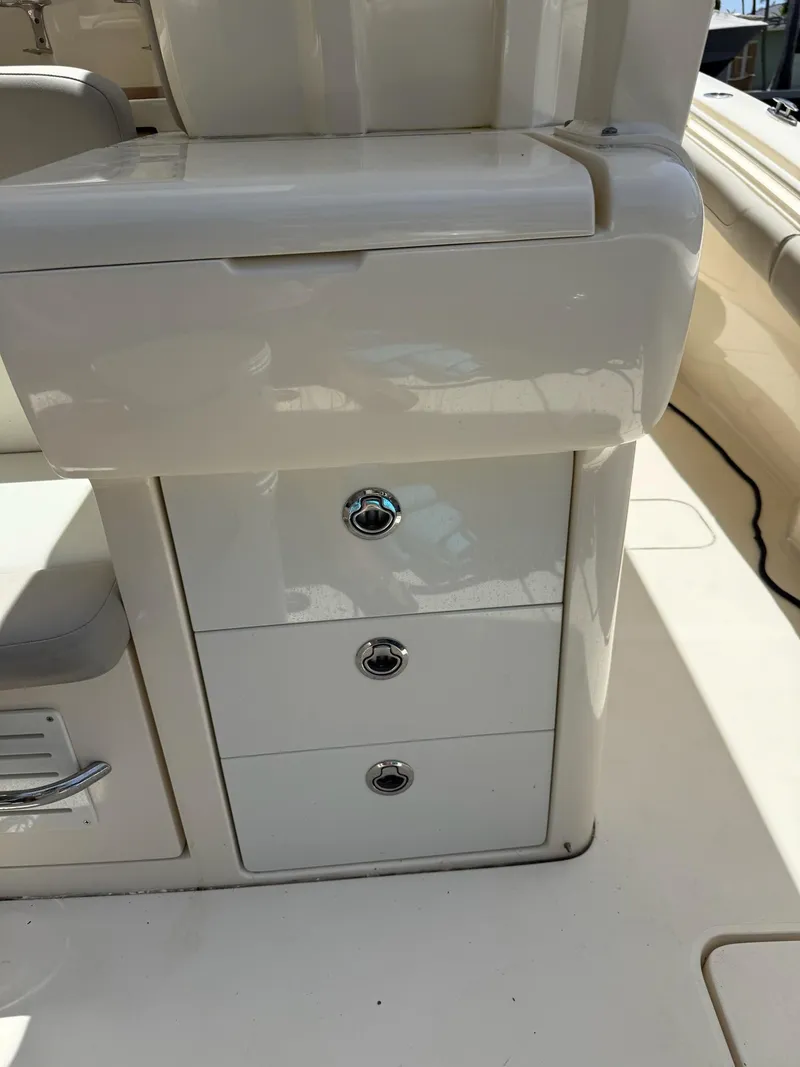 Slide: The Image of 2019 Scout 420 LXF boat seat and console detail, featuring sleek white design. - 47