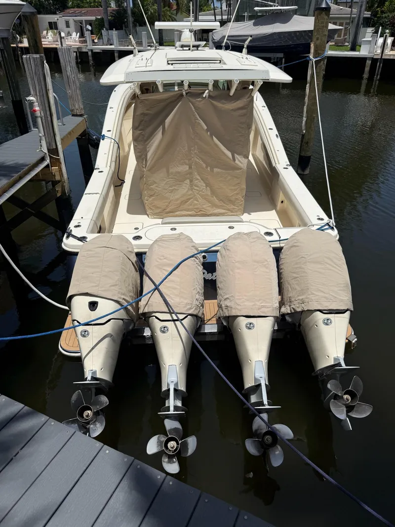 Slide: The Image of 2019 Scout 420 LXF boat docked with covered engines and beige canopy. - 9
