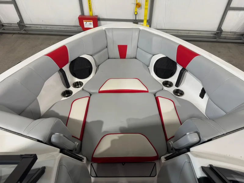 Slide: The Image of 2022 Malibu Wakesetter 23 LSV interior with gray and red seating, cup holders, and speakers. - 12