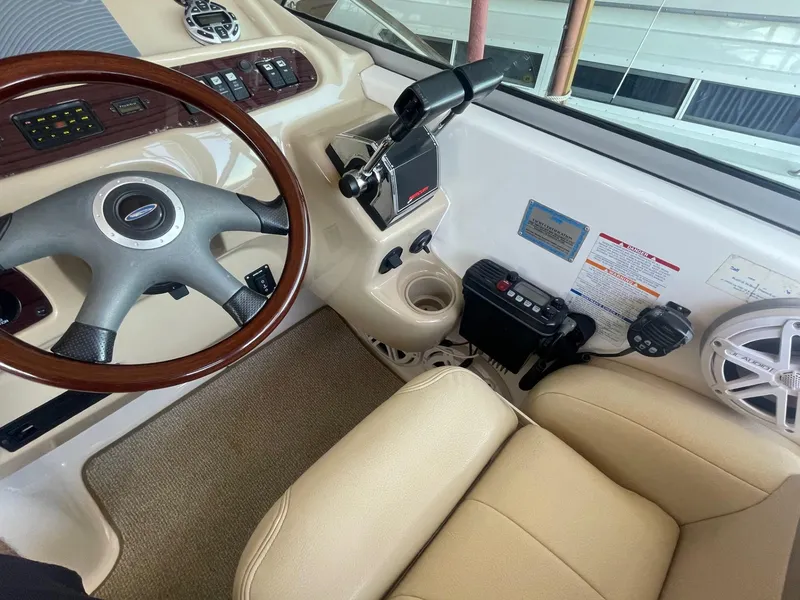 Slide: The Image of 2004 Chaparral Signature 290 helm with steering wheel, controls, and beige seating. - 11