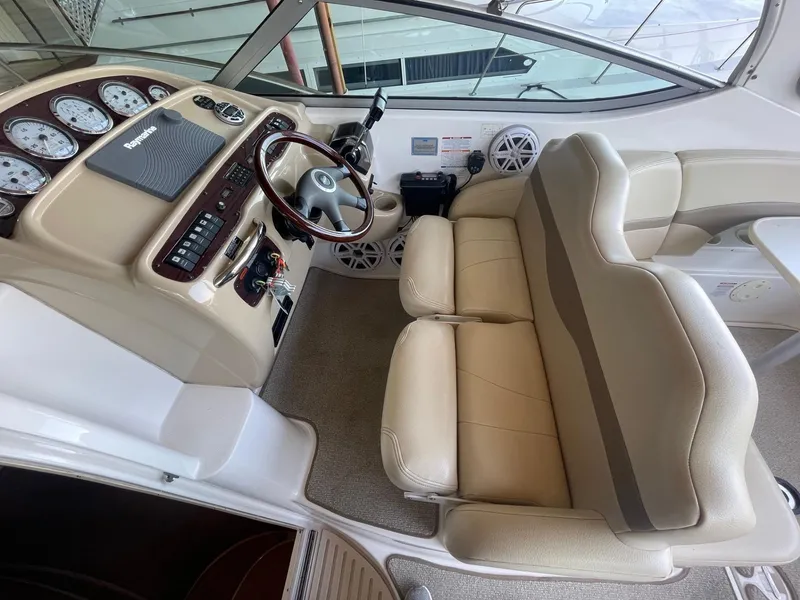 Slide: The Image of 2004 Chaparral Signature 290 boat cockpit with beige seating and control panel. - 12