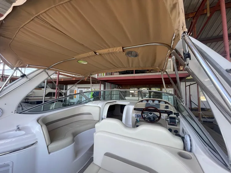 Slide: The Image of 2004 Chaparral Signature 290 boat interior with beige canopy and steering console. - 13