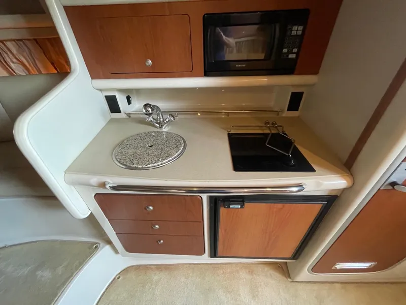 Slide: The Image of 2004 Chaparral Signature 290 boat kitchen with sink, microwave, and stove. - 19