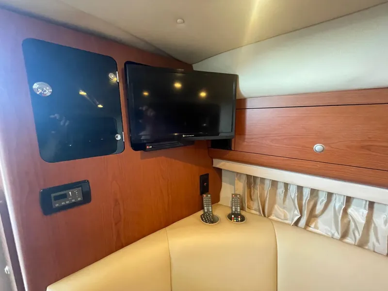 Slide: The Image of Interior of 2004 Chaparral Signature 290 with TV, remotes, and wood paneling. - 20