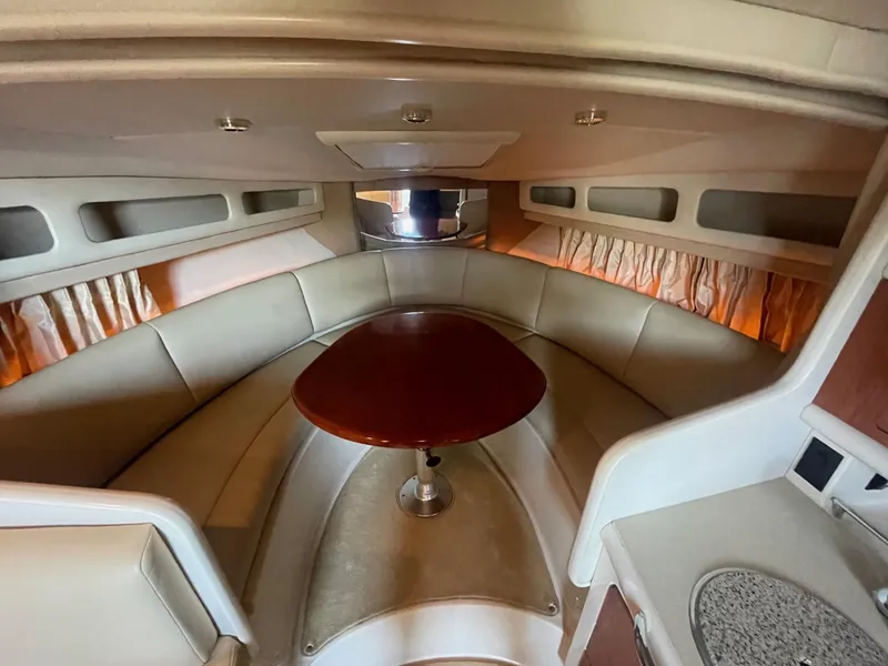 Slide: The Image of Interior of 2004 Chaparral Signature 290 boat with cozy seating and wooden table. - 21