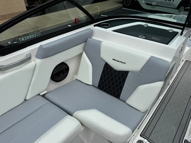 Slide: The Image of 2023 MasterCraft XT23 boat interior with gray and white seating, featuring branded upholstery. - 10