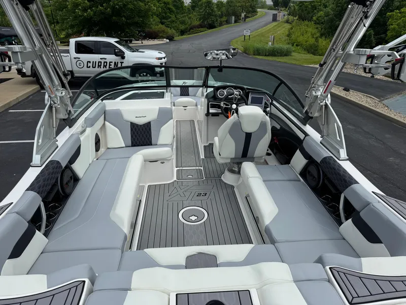 Slide: The Image of 2023 MasterCraft XT23 boat interior with sleek seating and modern dashboard. - 13