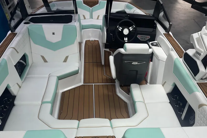 Slide: The Image of 2025 Nautique Super Air Nautique GS20 interior with white and teal seating, wood accents. - 8