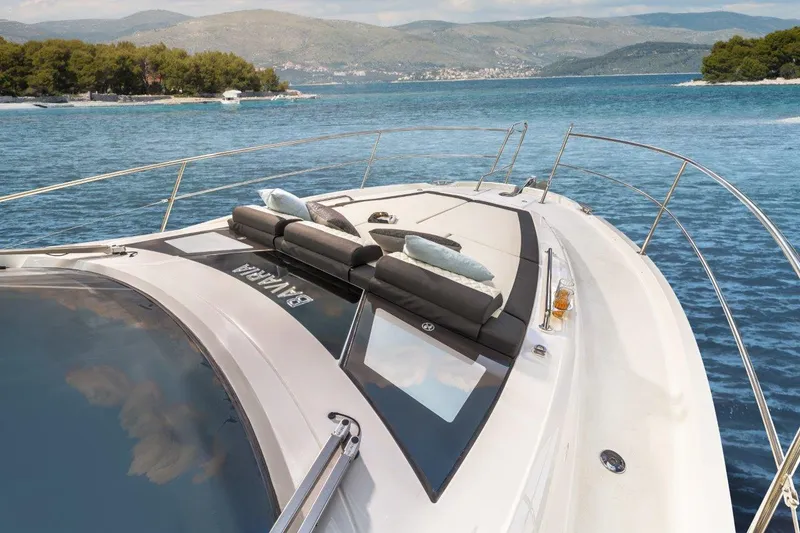 Slide: The Image of 2023 Bavaria SR41 COUPE yacht cruising on a scenic lake with mountains in the background. - 8