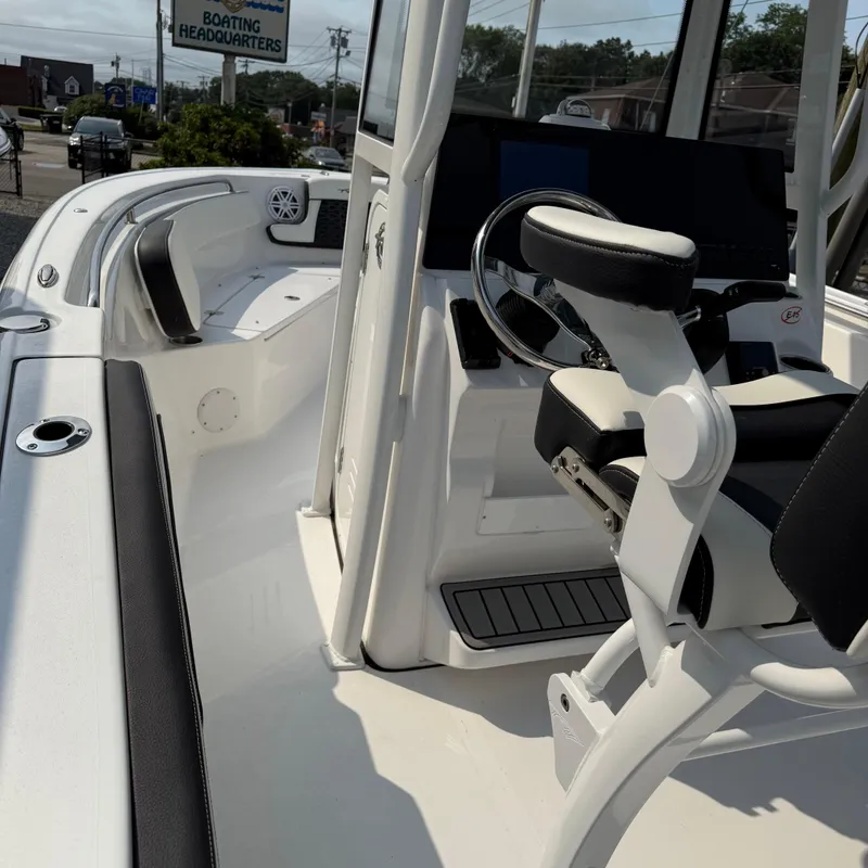 Slide: The Image of 2026 Tidewater 210CC boat interior with steering wheel and seating, at a boating headquarters. - 8