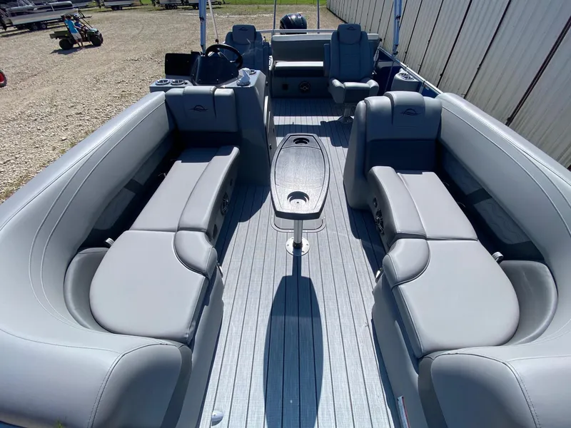 Slide: The Image of 2025 SunCatcher Fusion 324SL pontoon boat interior with gray seating and central table. - 8