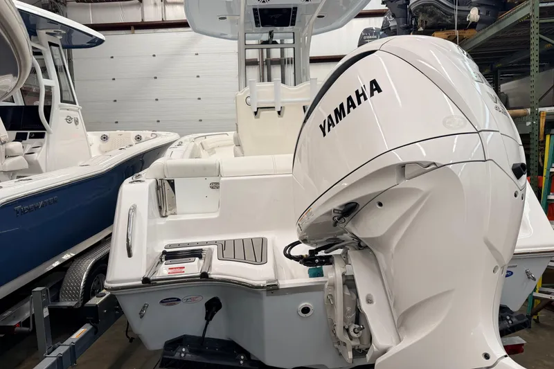 Slide: The Image of 2026 Tidewater 232 LXF boat interior with rod holders and overhead speakers in a showroom. - 8