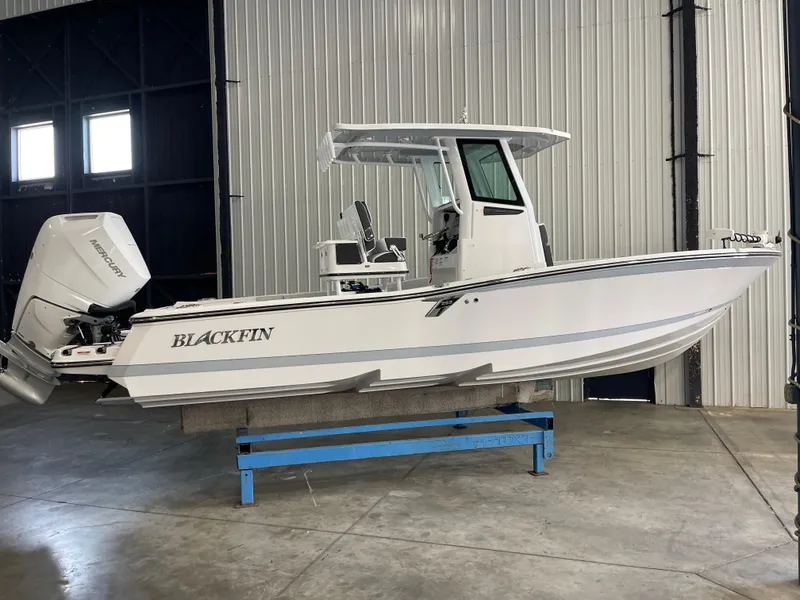 The Image of 2026 Blackfin 262 HB boat in a warehouse, featuring a Mercury outboard engine. - 1