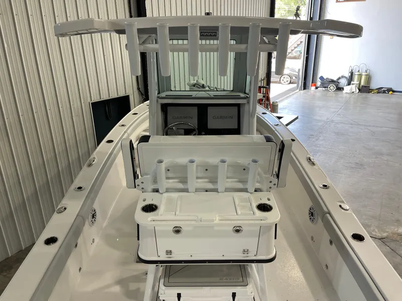 Slide: The Image of 2026 Blackfin 262 HB boat interior with Garmin electronics and rod holders in a garage setting. - 14