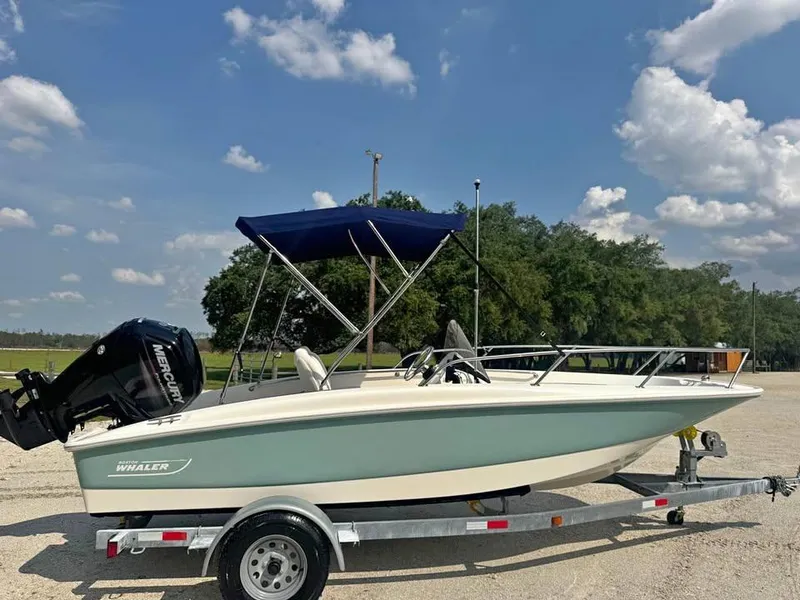 Slide: The Image of 2016 Boston Whaler 170 Super Sport boat on trailer under blue sky. - 1