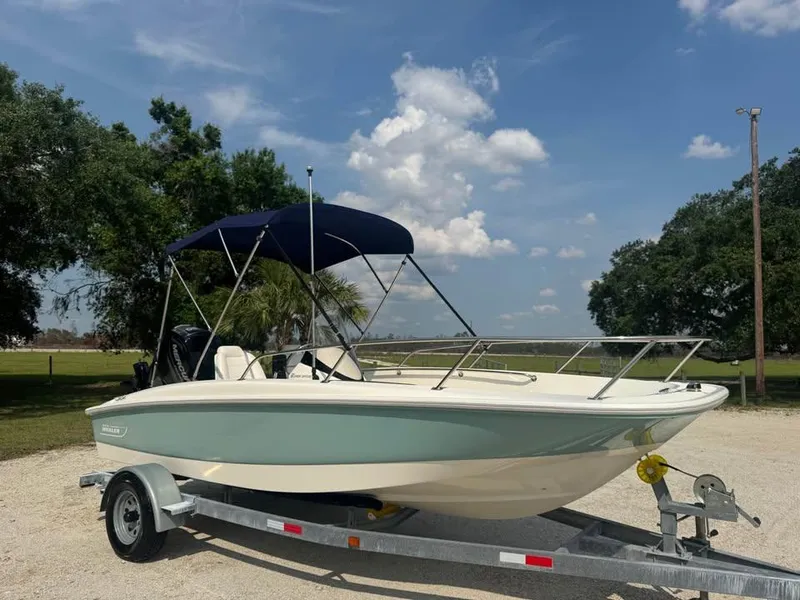 Slide: The Image of 2016 Boston Whaler 170 Super Sport boat on trailer under blue sky. - 2