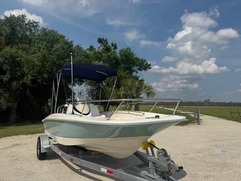 Slide: The Image of 2016 Boston Whaler 170 Super Sport boat on trailer under blue sky. - 4