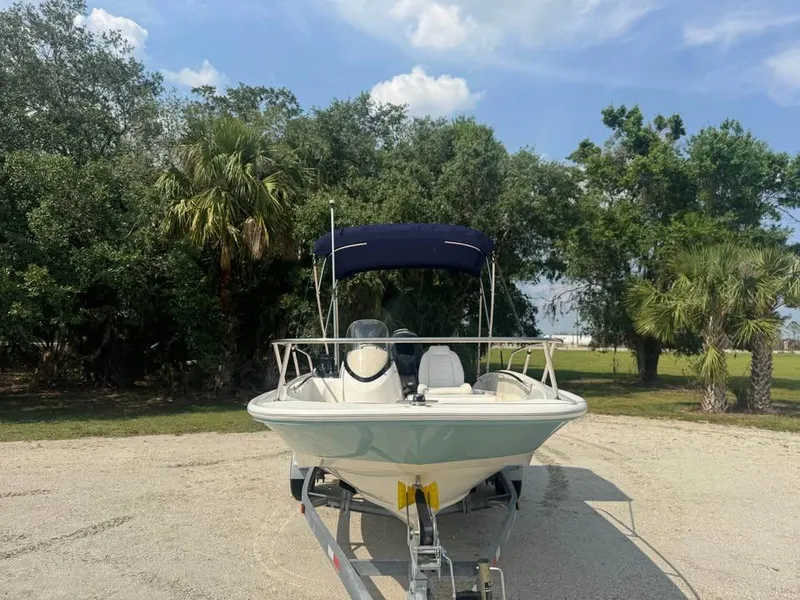 Slide: The Image of 2016 Boston Whaler 170 Super Sport boat on trailer, surrounded by trees. - 7